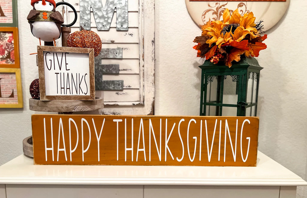 Happy Thanksgiving golden amber farmhouse wood sign with white hand-painted lettering free-standing on white console table with Gobble Gobble reversible block sign and fall floral lantern close up