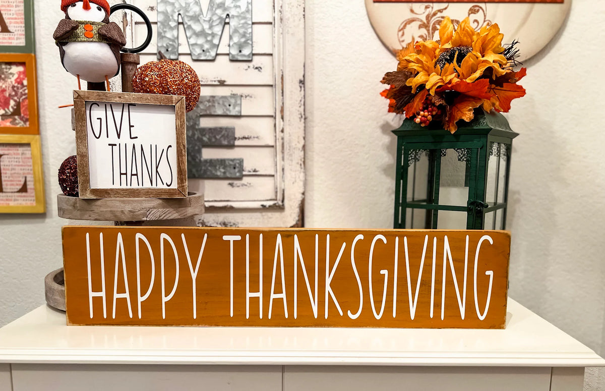 Happy Thanksgiving golden amber farmhouse wood sign with white hand-painted lettering free-standing on white console table with Gobble Gobble reversible block sign and fall floral lantern close up