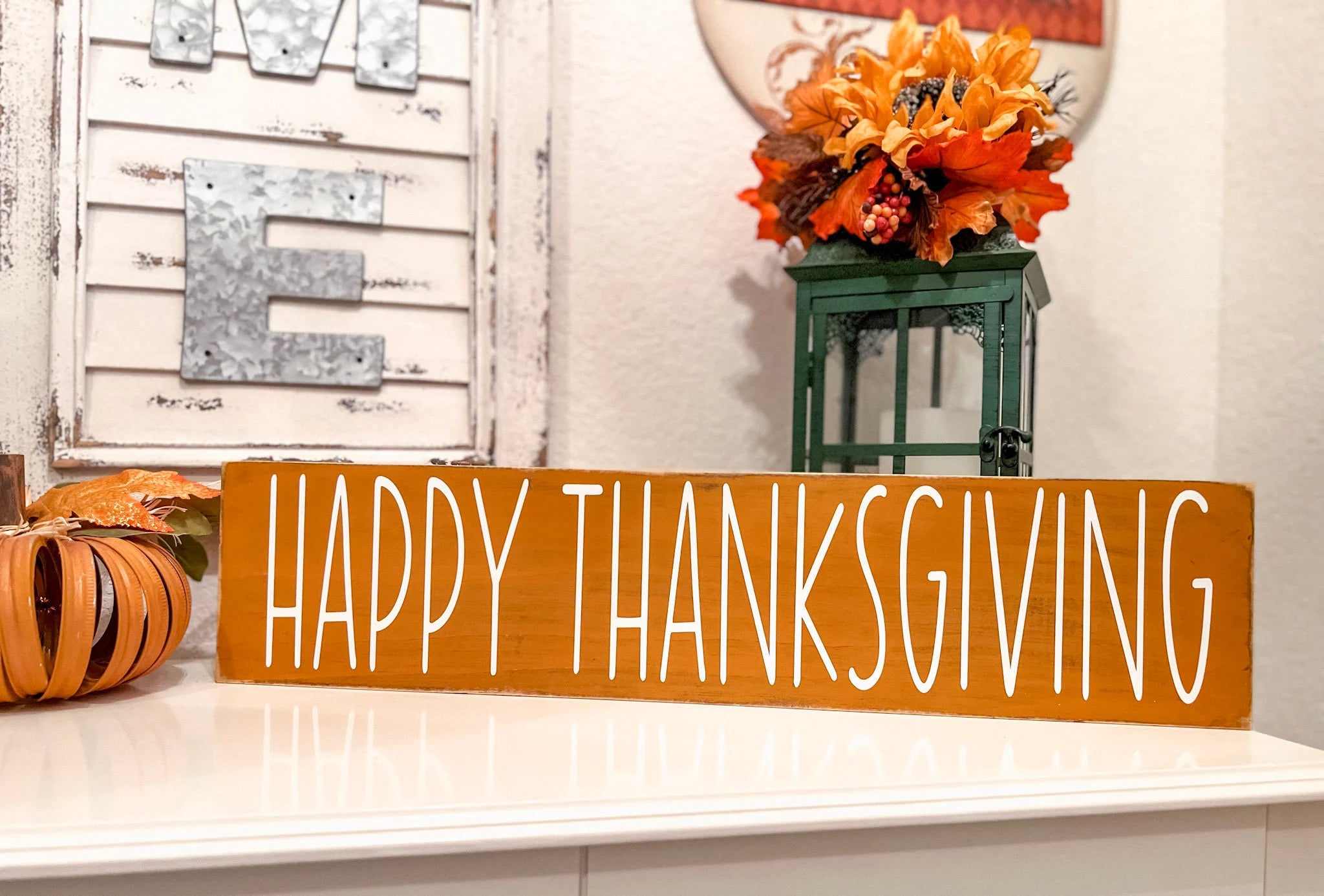 Happy Thanksgiving golden amber farmhouse wood sign with white hand-painted lettering free-standing on white console table product hero shot