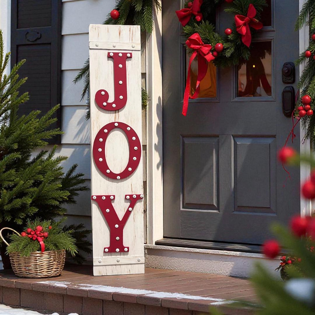 JOY porch leaner sign with red marquee letters leaning against gray front door with Christmas wreath and berry basket