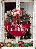 Red Merry Christmas round pine wood door hanger with frosted berry swag and red cream gold glitter bow hung in rustic white window frame with Christmas tree and red ornaments in background