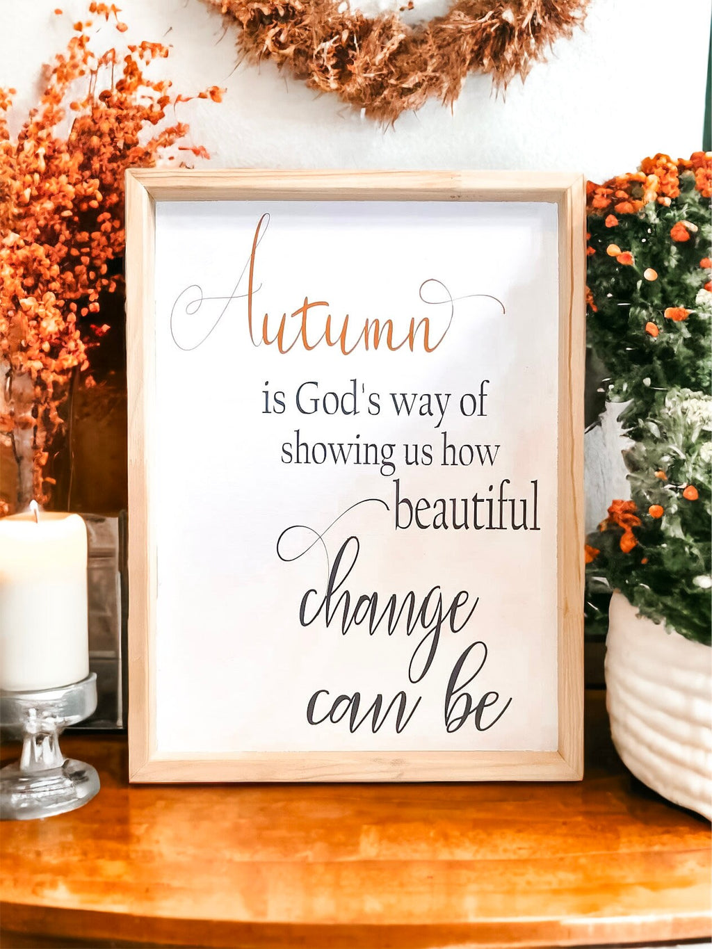 Autumn is Gods Way framed wood sign with copper and black lettering in whitewashed birch frame on white surface with orange and white pumpkins and textured cylinder vase wide shot