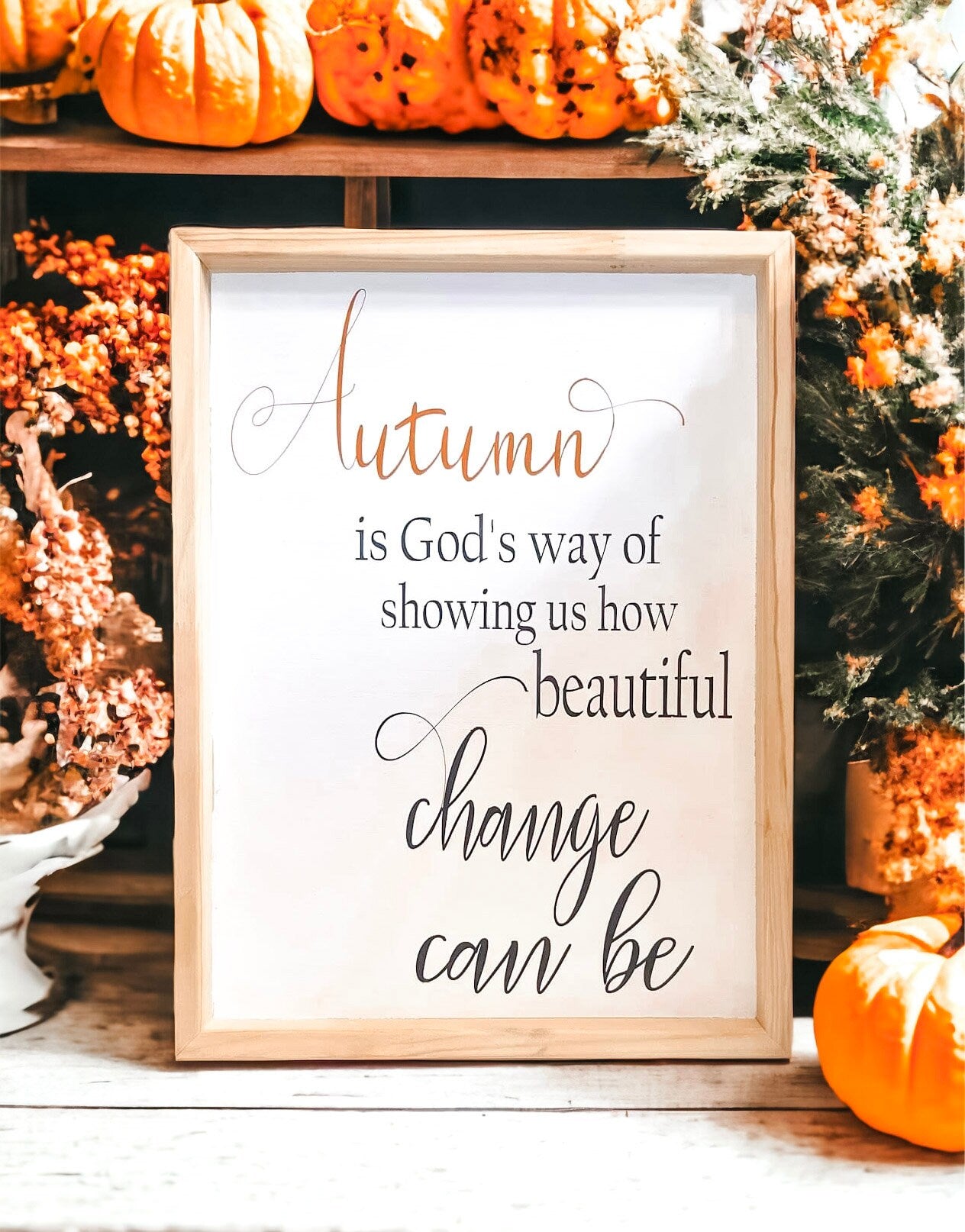 Autumn is Gods Way framed wood sign with copper and black lettering in whitewashed birch frame on white mantel with fall leaf garland above and orange pumpkin beside