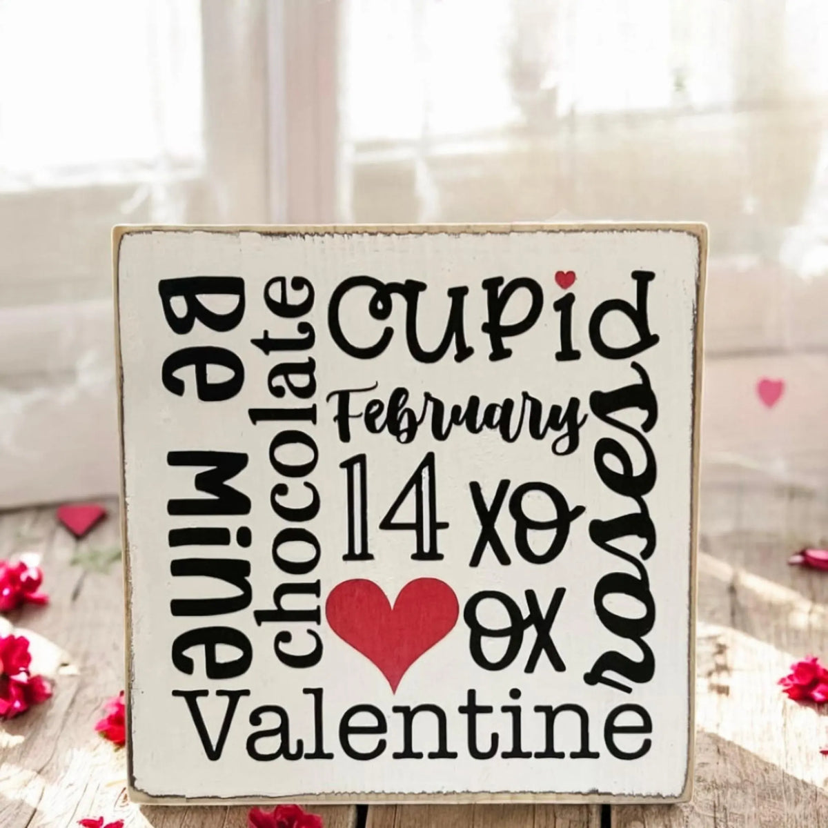 Valentine sayings wood block on rustic wood table with winter greenery and red berries