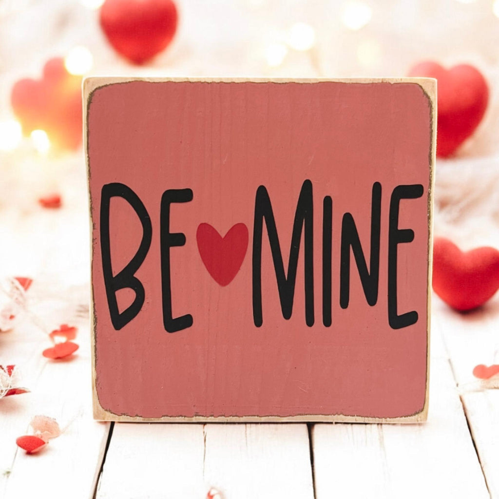 Be Mine Valentine wood block sign on rustic wood surface with red roses close up