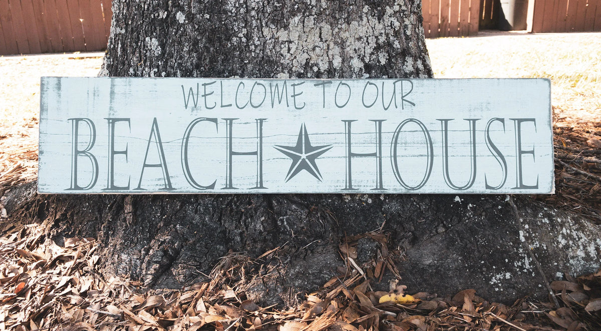 Welcome to Our Beach House reclaimed wood sign on wood shelf with white lantern anchor and coastal decor