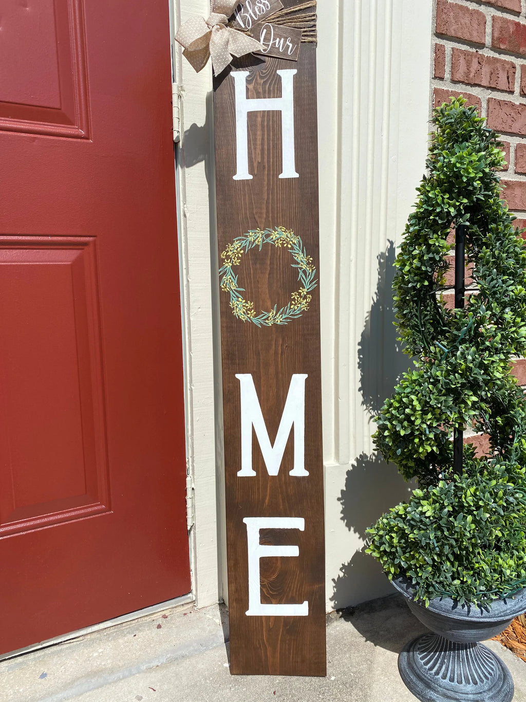 Bless Our Home porch leaner sign in light walnut full length view with boxwood topiary