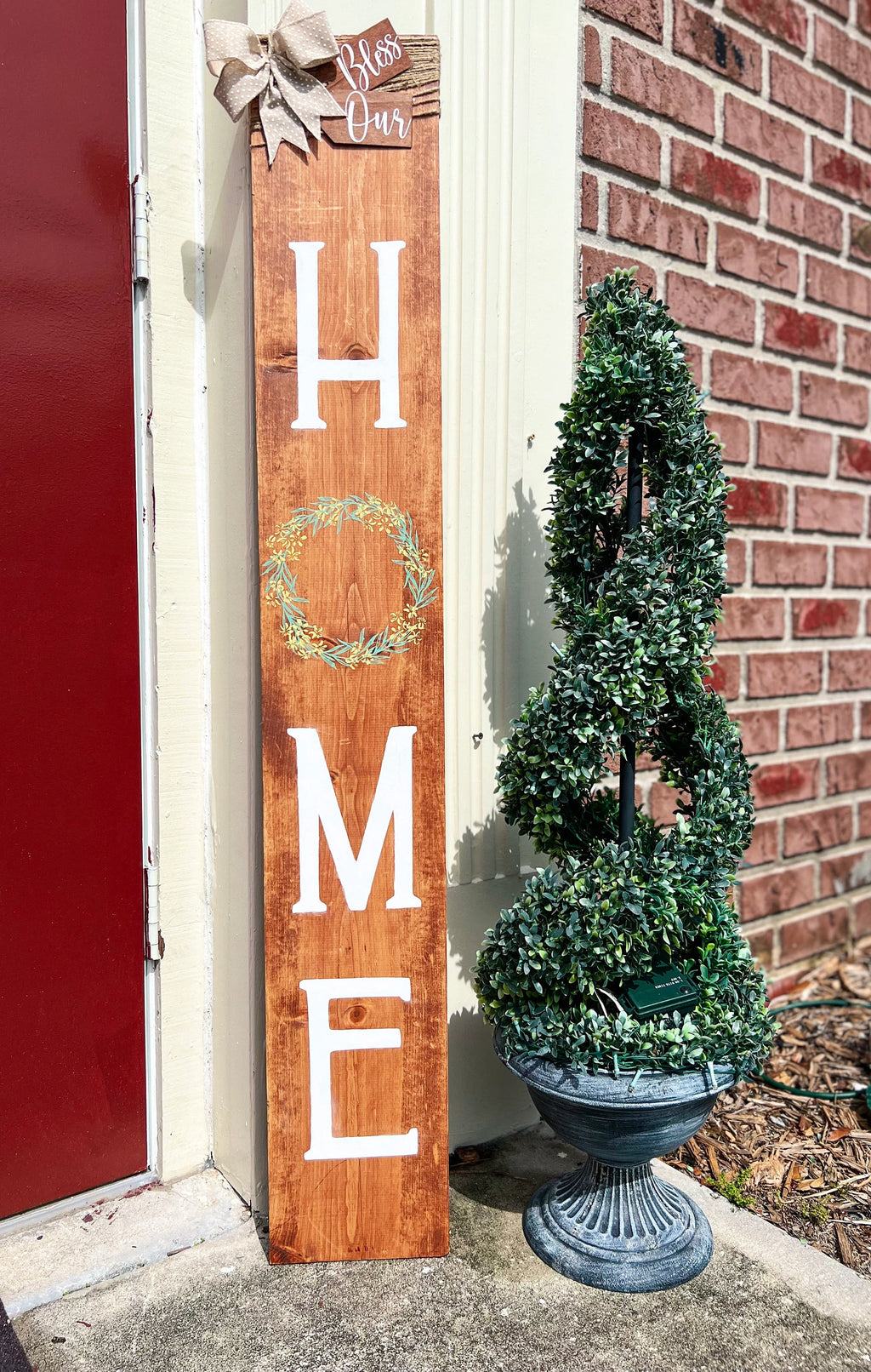 Bless Our Home porch leaner sign in dark walnut with burlap bow close up showing Bless Our tag and wreath
