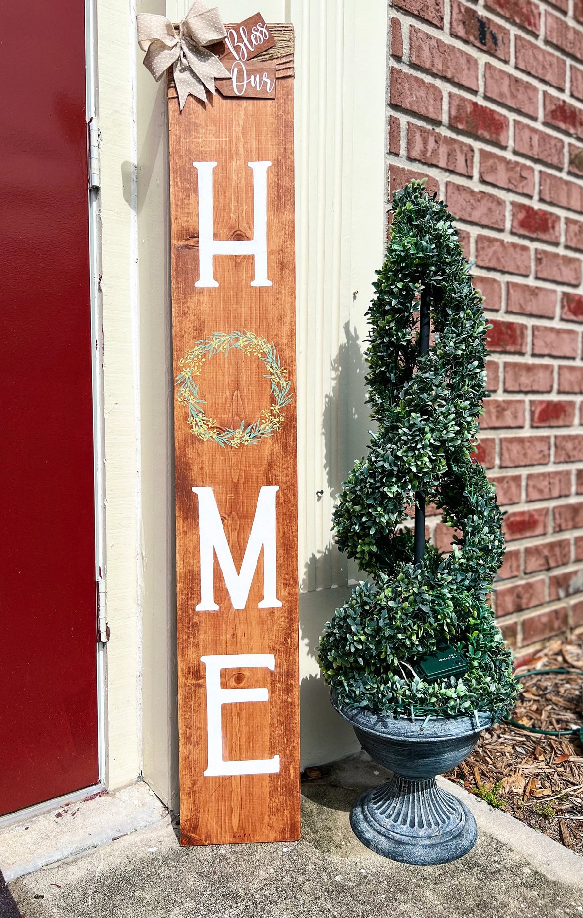 Bless Our Home porch leaner sign in dark walnut with burlap bow close up showing Bless Our tag and wreath