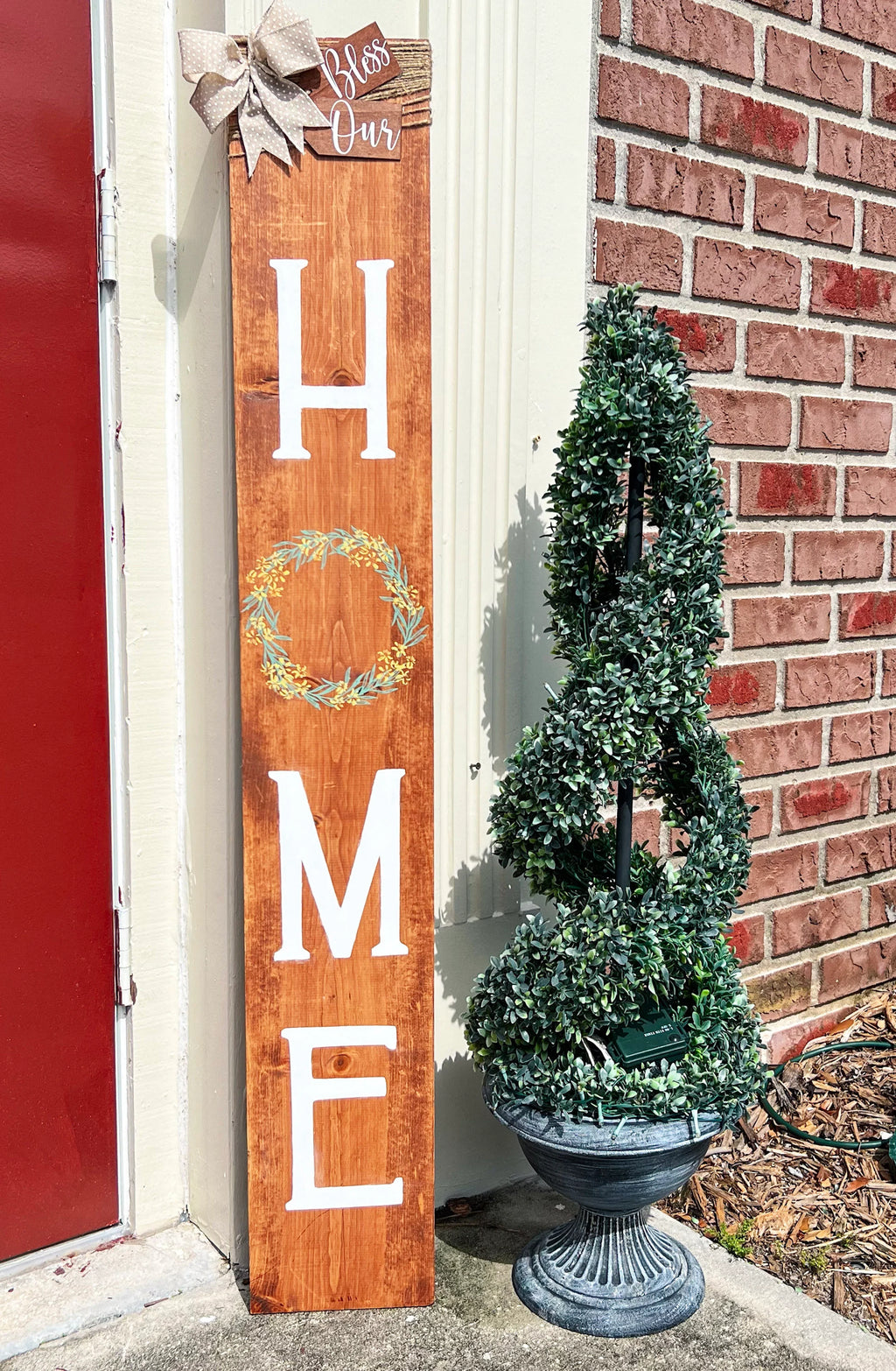 Bless Our Home porch leaner sign in dark walnut close up showing HOME lettering and wreath detail