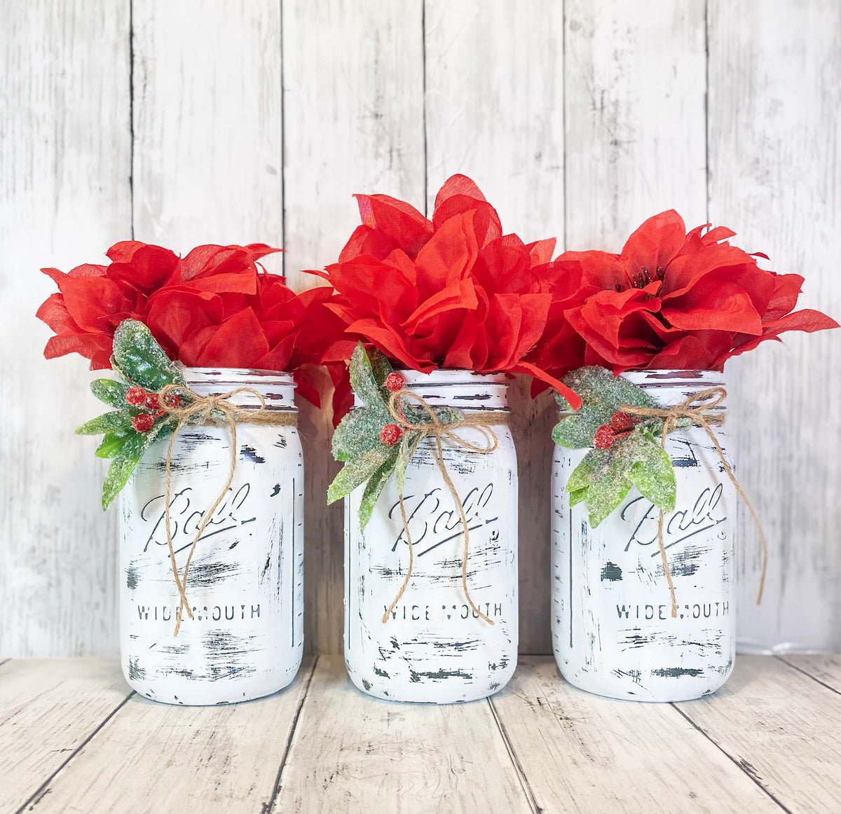 Set of three Christmas mason jars with red poinsettias bright background