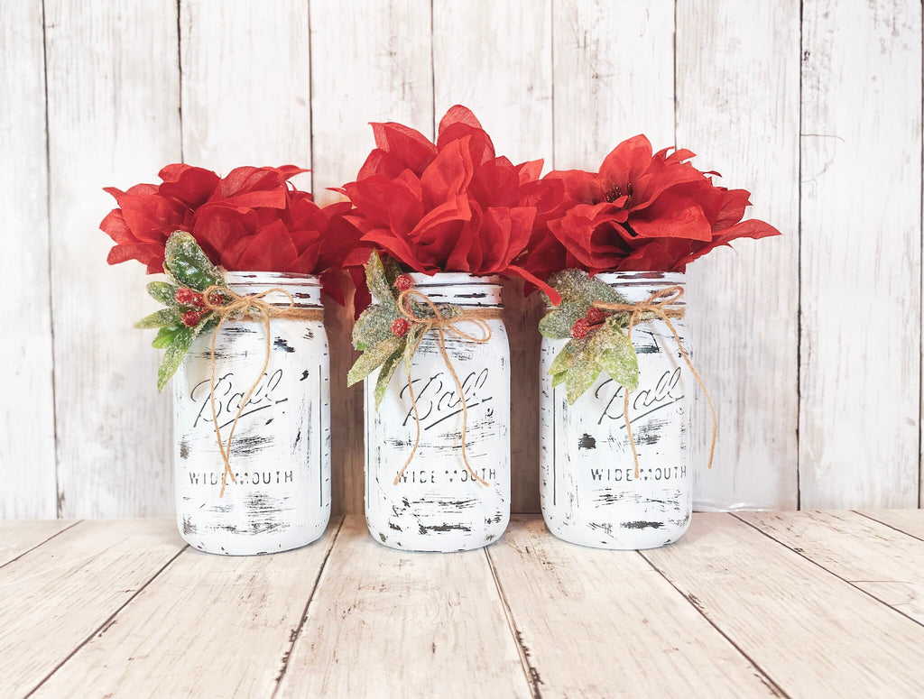 Distressed white mason jars with holly berries and jute twine front view