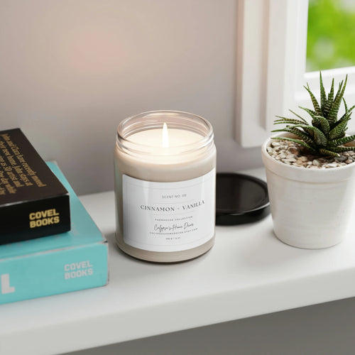 Cinnamon Vanilla candle lit on windowsill with succulent and books