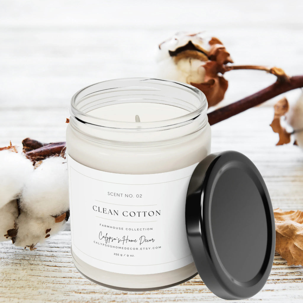 Clean Cotton soy candle Scent No. 02 Farmhouse Collection lit on white wood surface with cotton stems in background