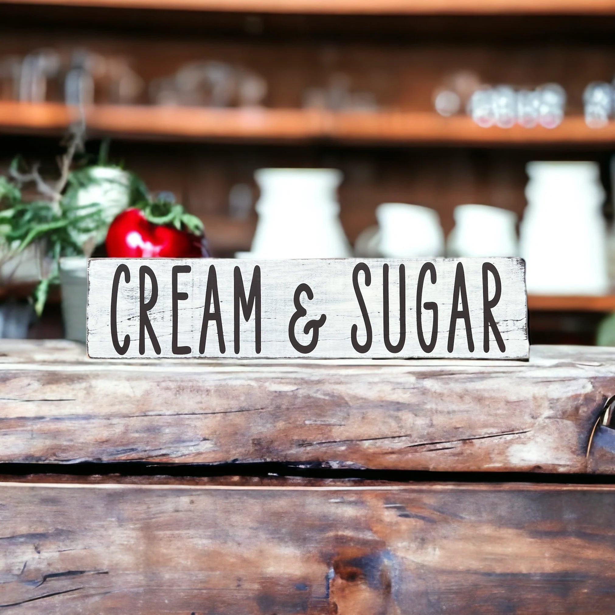 Cream and Sugar distressed white farmhouse wood sign on dark wood kitchen table with wicker basket in background