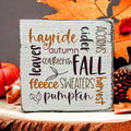 Fall Favorites word cloud wood block sign on wood dining table with white flowers and vase in background