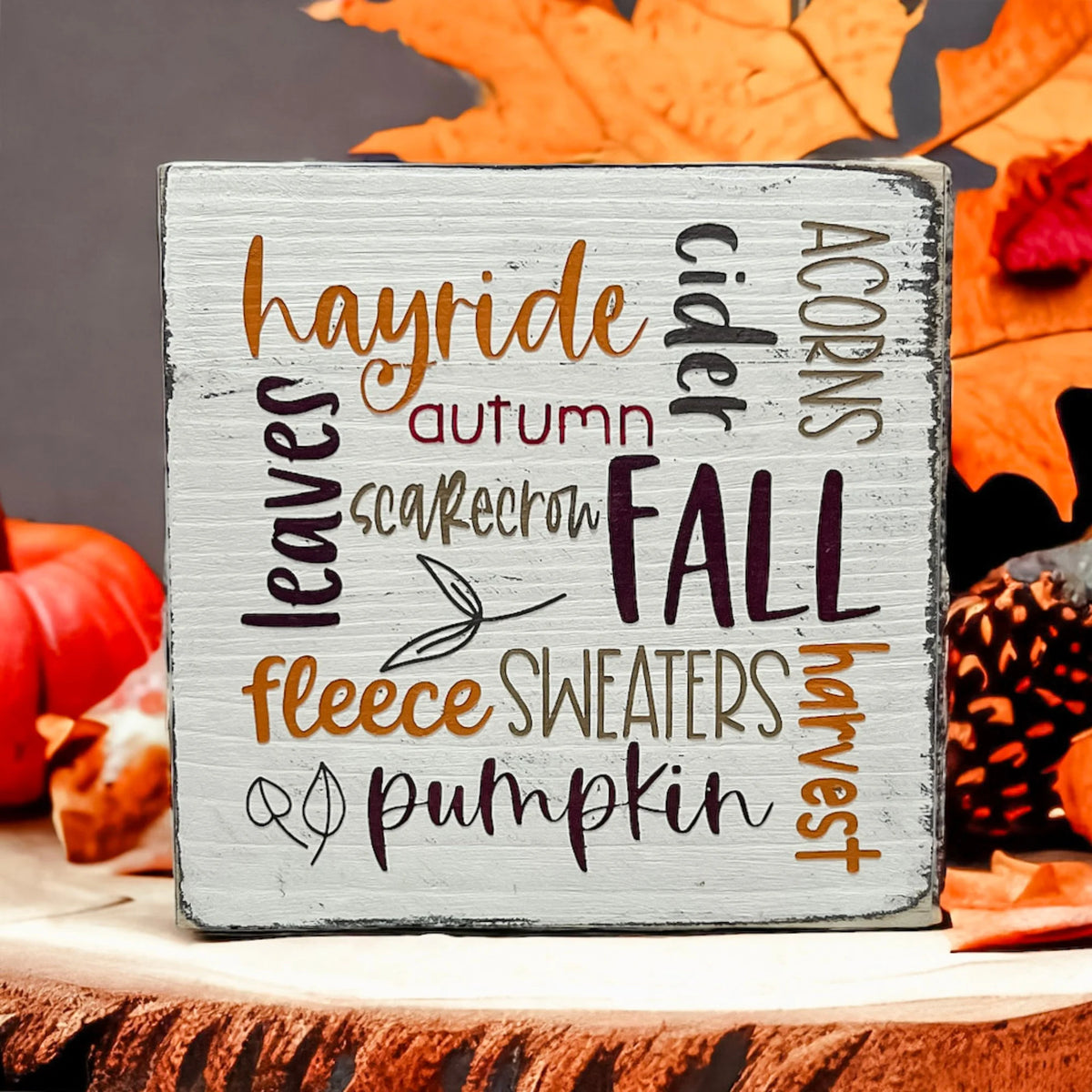 Fall Favorites word cloud wood block sign on wood dining table with white flowers and vase in background