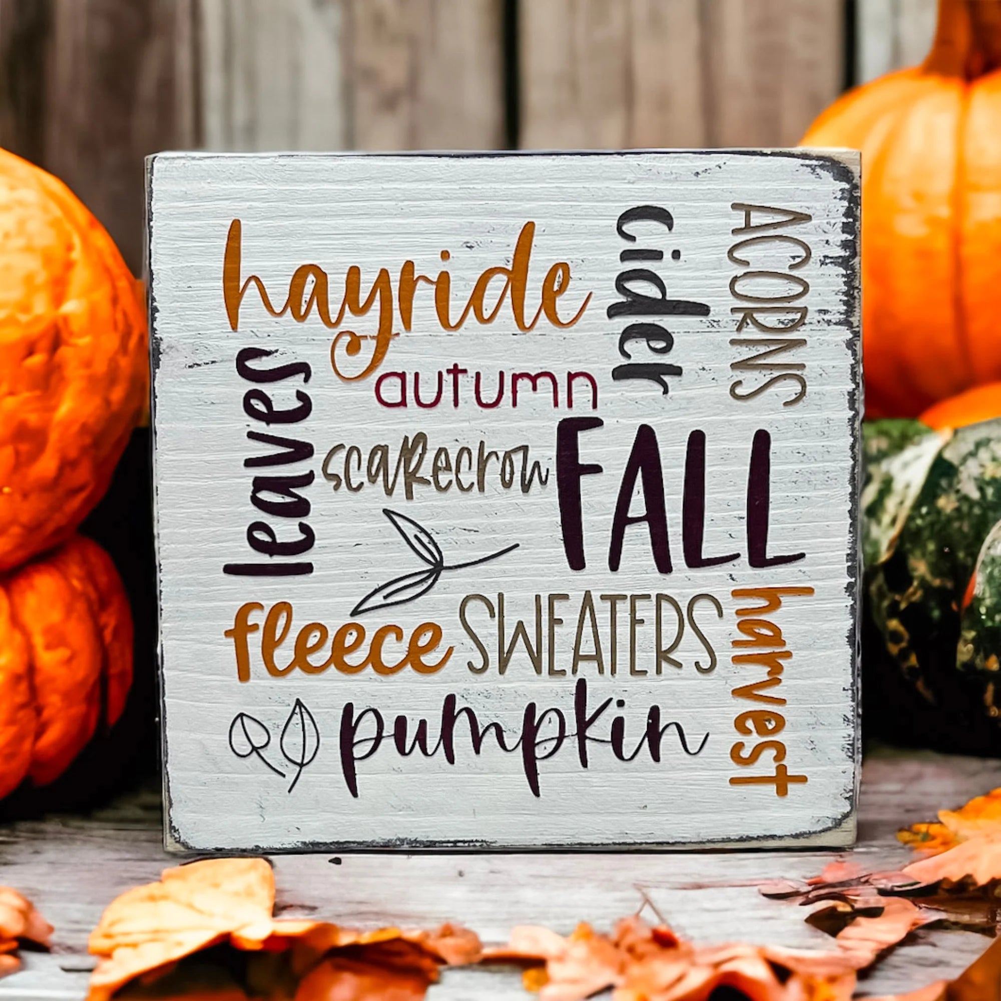 Fall Favorites word cloud wood block sign on rustic wood surface in wicker tray with candle in background