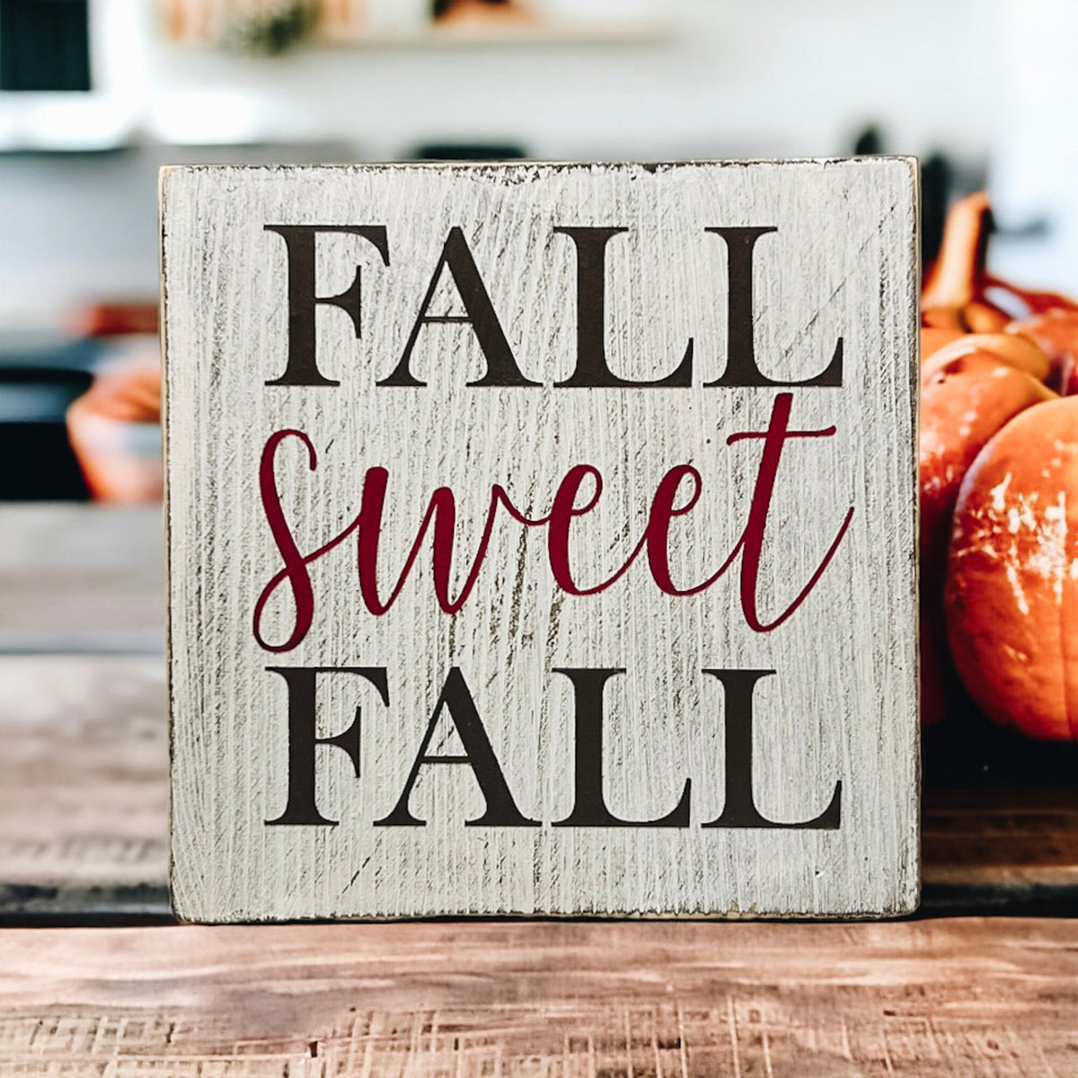 Fall Sweet Fall distressed white wood block sign on white mantel with glittery pumpkins and red berry stems and pine tree