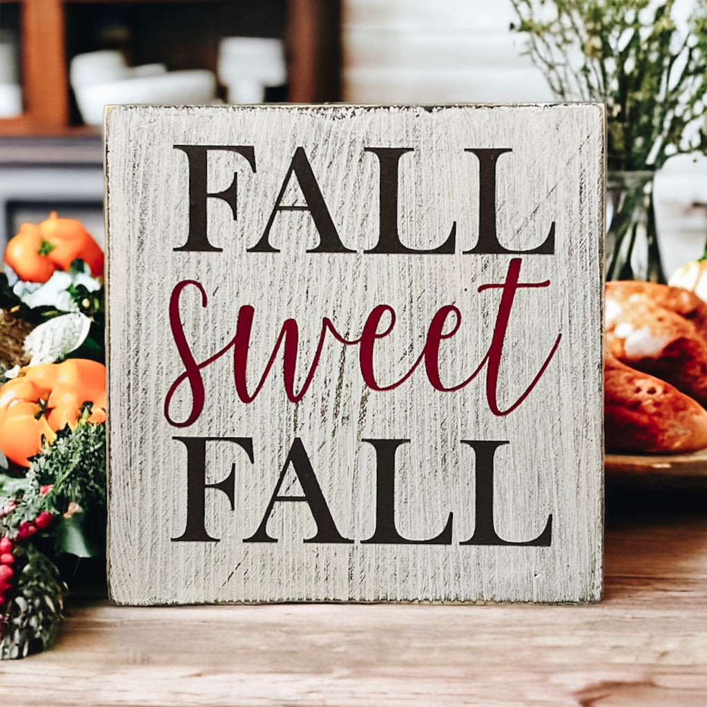 Fall Sweet Fall distressed white wood block sign on white cake stand with orange pumpkins and white velvet pumpkins
