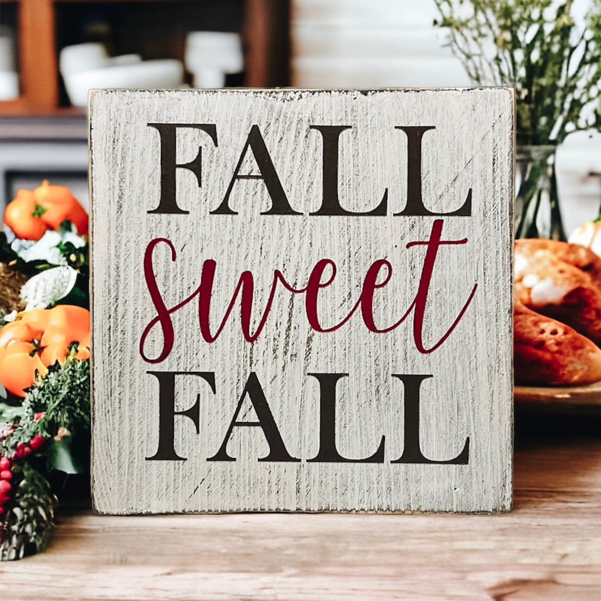 Fall Sweet Fall distressed white wood block sign on white cake stand with orange pumpkins and white velvet pumpkins