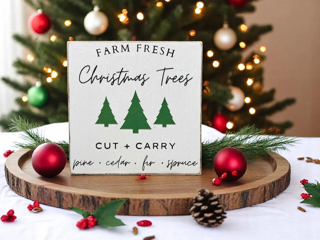 Farm Fresh Christmas Trees wood block sign on white windowsill with pine garland and pinecone bowl