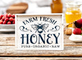 Farm Fresh Honey framed reclaimed wood sign with navy bee graphic and chalk paste lettering in distressed whitewash frame on rustic wood surface with honey jars blueberries and raspberries