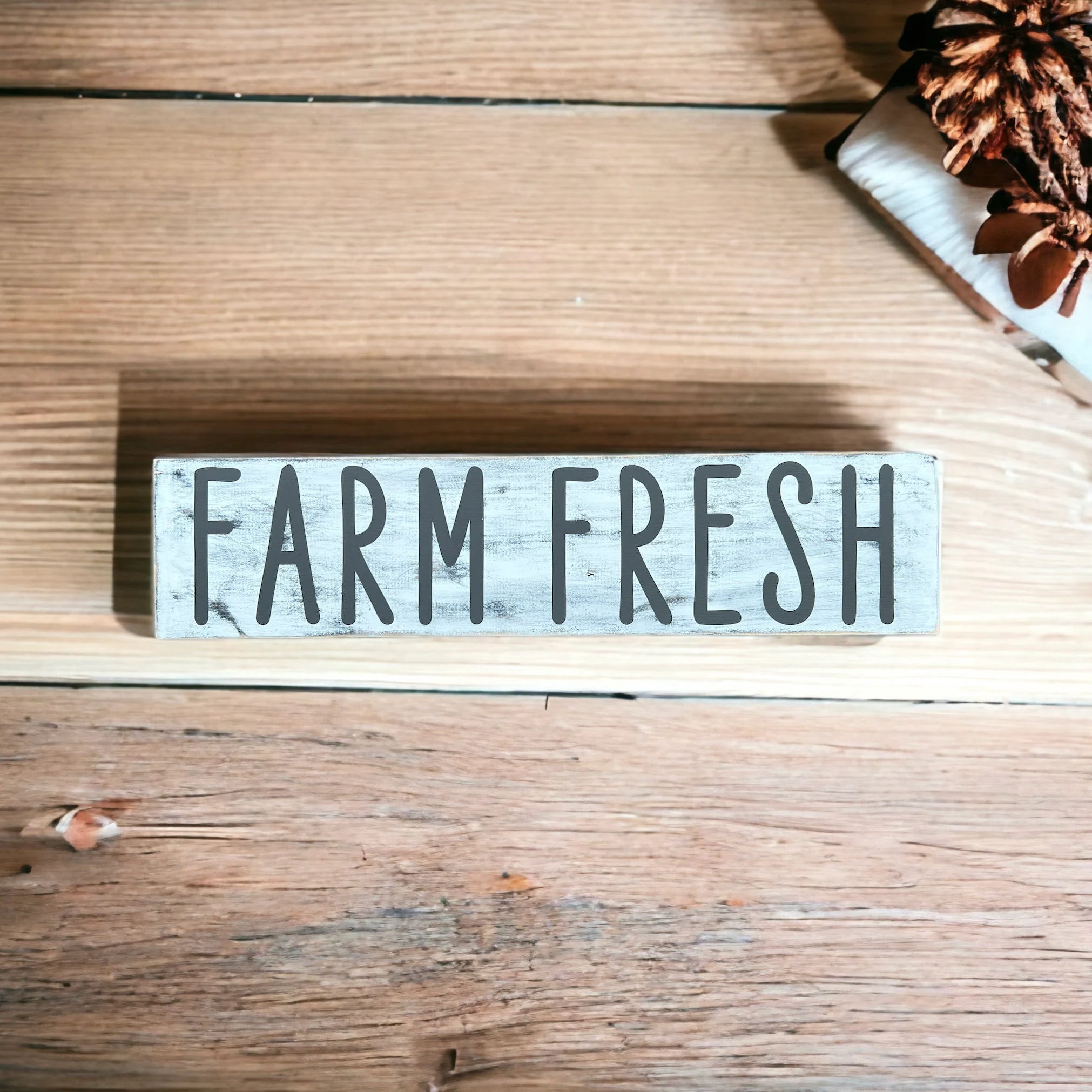 Farm Fresh distressed white wood sign with dark grey lettering on white marble kitchen island with modern kitchen background
