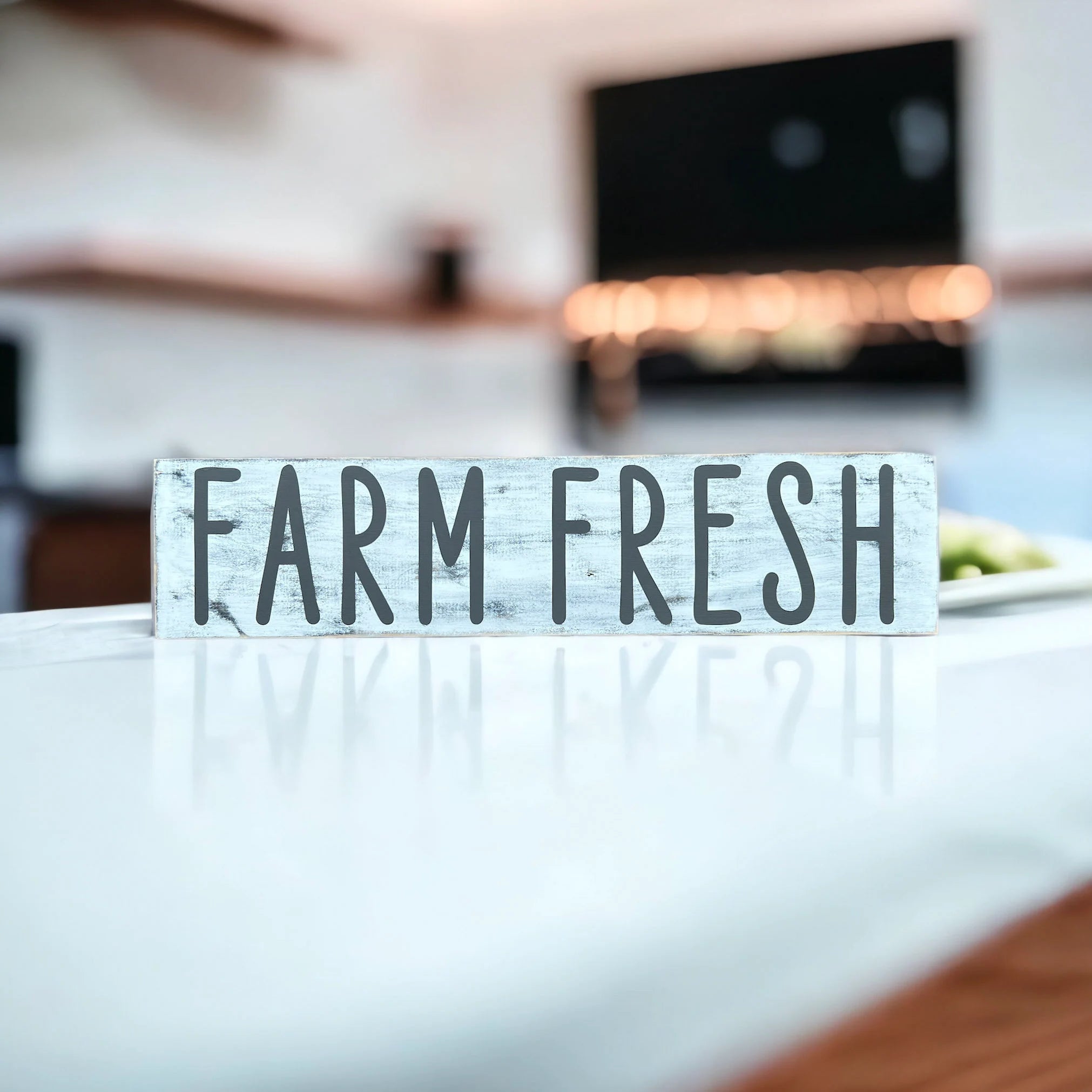 Farm Fresh distressed white wood sign with dark grey lettering on white marble kitchen counter with bokeh background