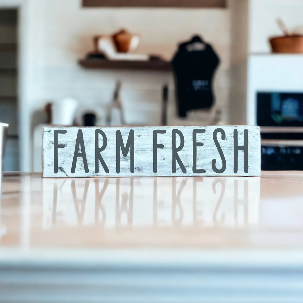 Farm Fresh distressed white wood sign with dark grey lettering on white marble counter wide lifestyle shot