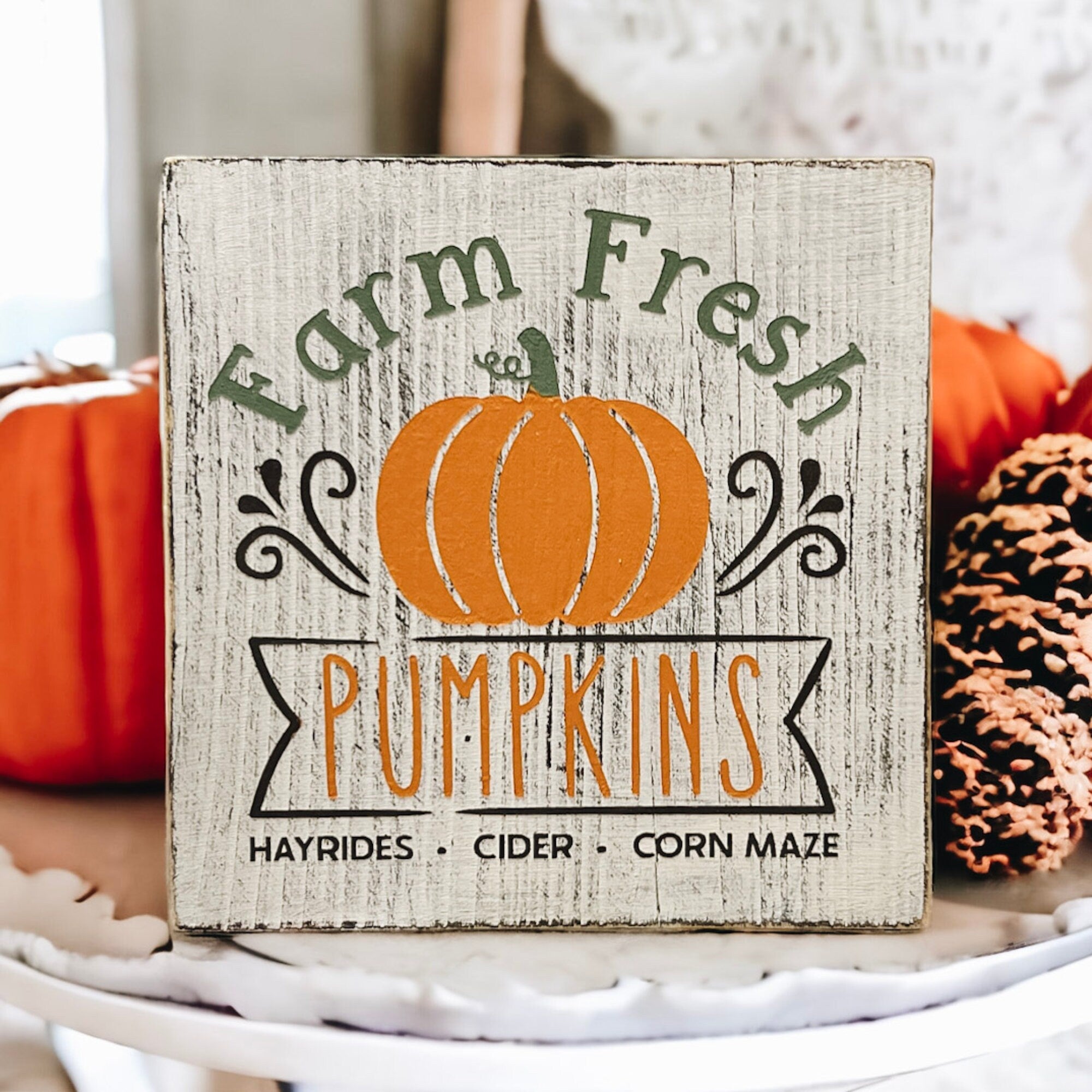 Farm Fresh Pumpkins wood block sign on rustic wood table with pumpkins in background