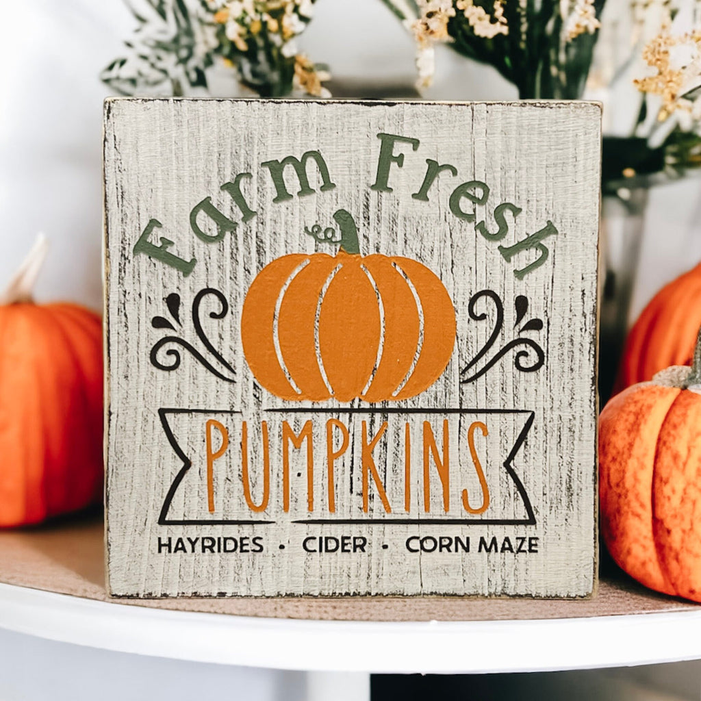 Farm Fresh Pumpkins wood block sign on white plate with orange pumpkins and fall decor