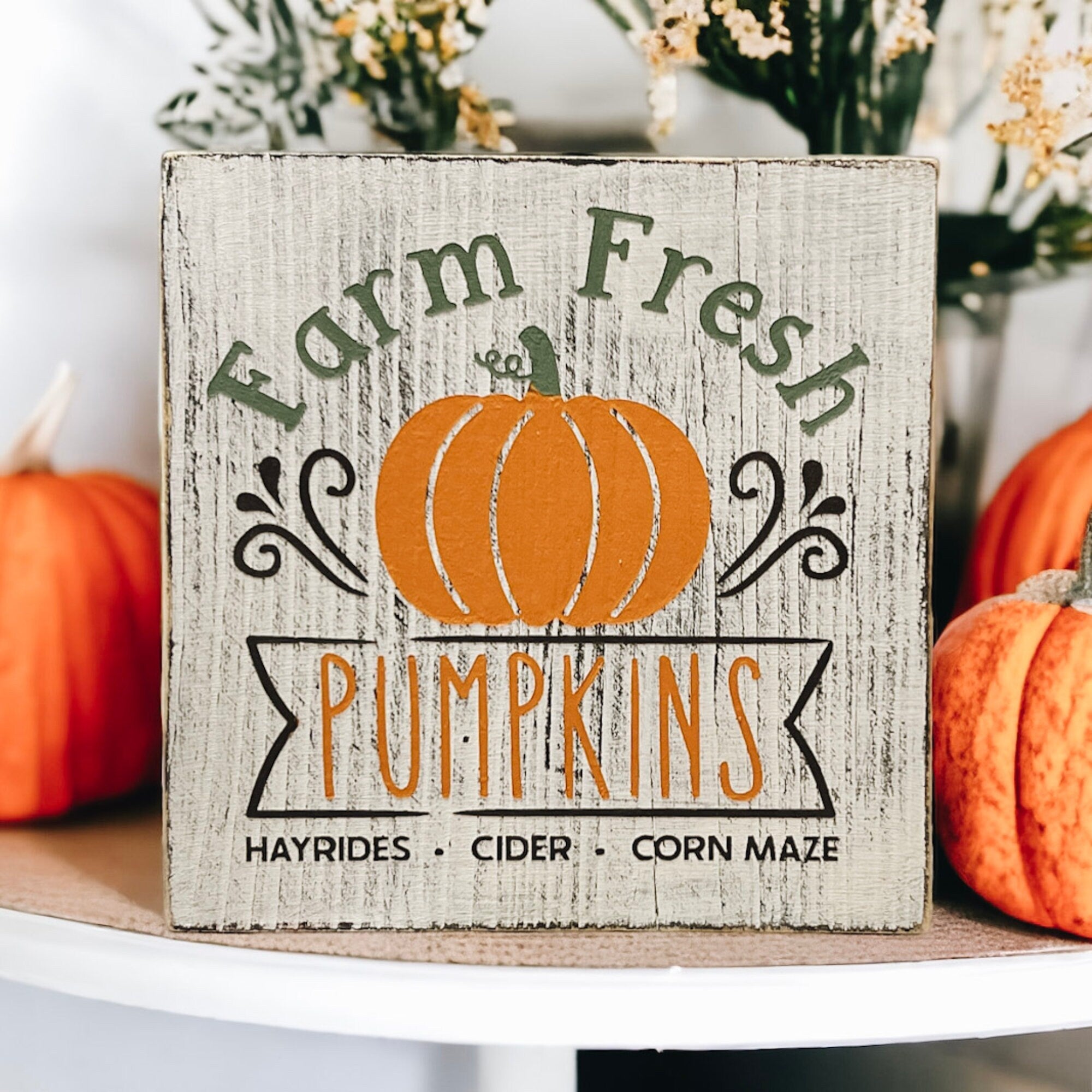 Farm Fresh Pumpkins wood block sign on white plate with orange pumpkins and fall decor