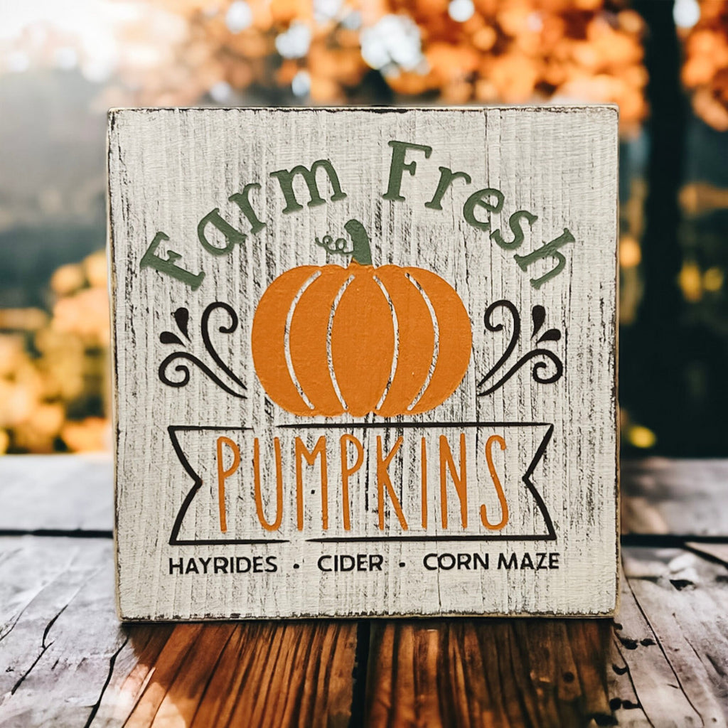 Farm Fresh Pumpkins wood block sign on white tiered tray with orange pumpkins and white flowers