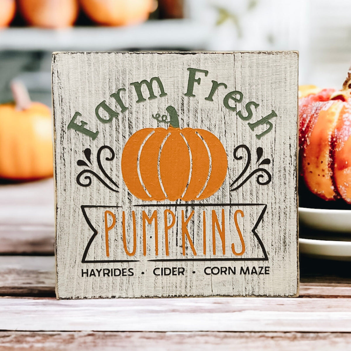 Farm Fresh Pumpkins wood block sign front view on white surface with fall pumpkin arrangement