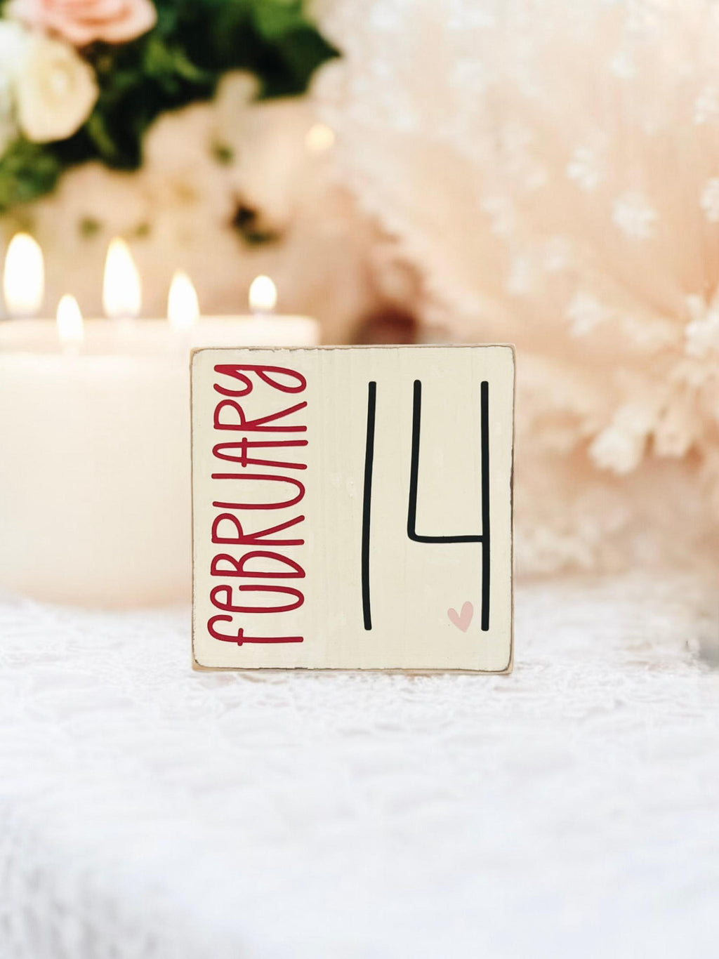 February 14 sign on rustic wood surface with red roses and bokeh lights