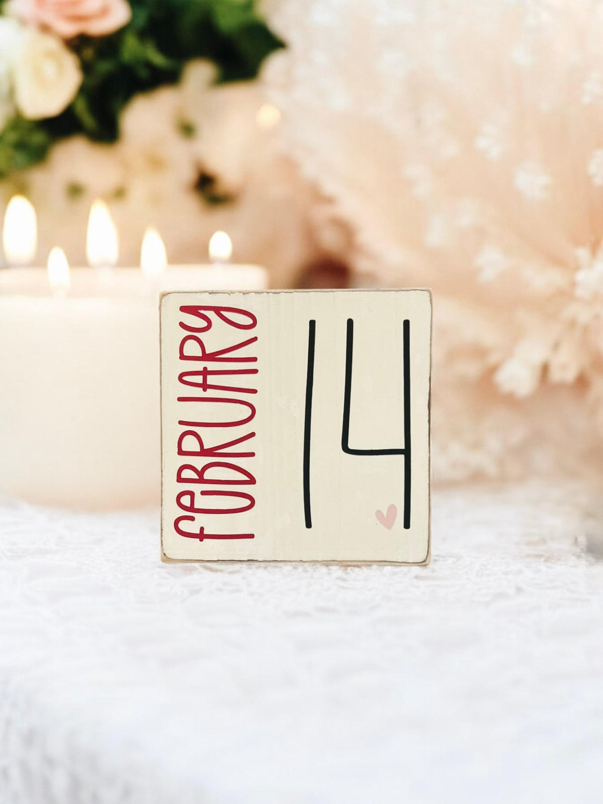 February 14 sign on rustic wood surface with red roses and bokeh lights