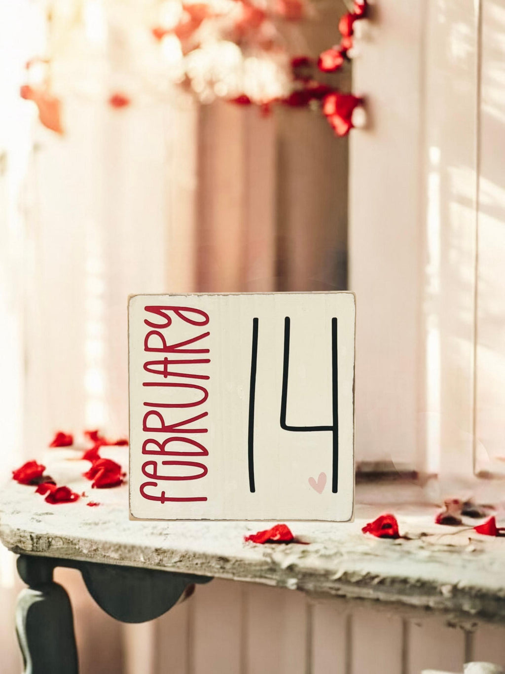 February 14 sign front view on rustic wood with red roses in background
