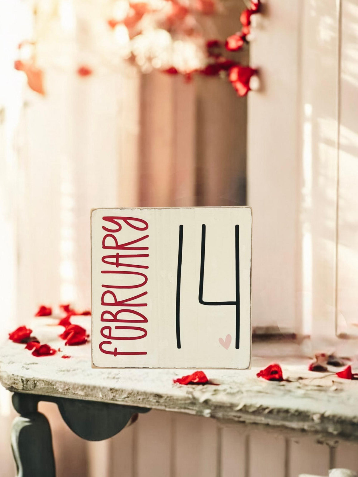 February 14 sign front view on rustic wood with red roses in background
