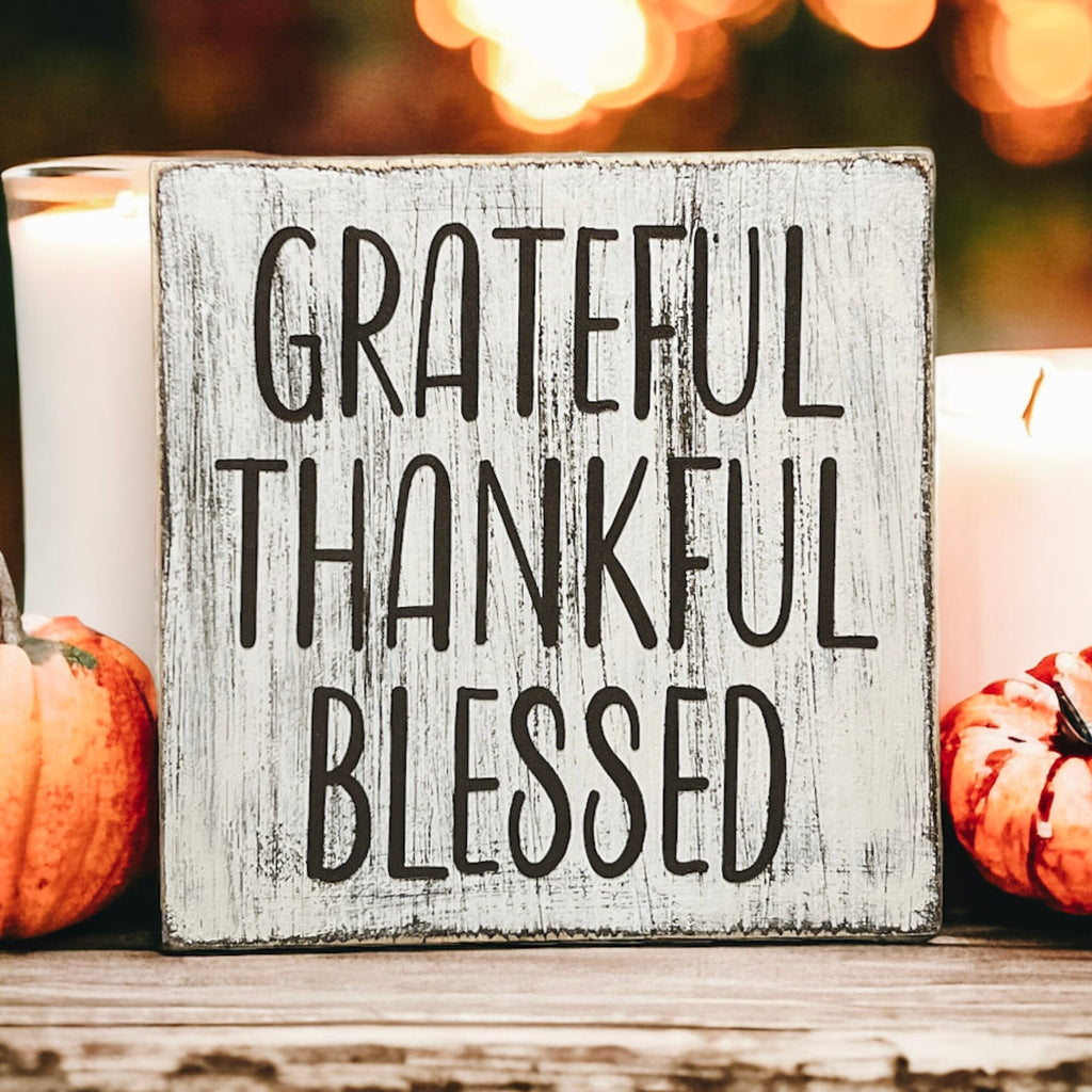 Grateful Thankful Blessed distressed white wood block sign on white mantel with orange pumpkins and glitter pumpkins