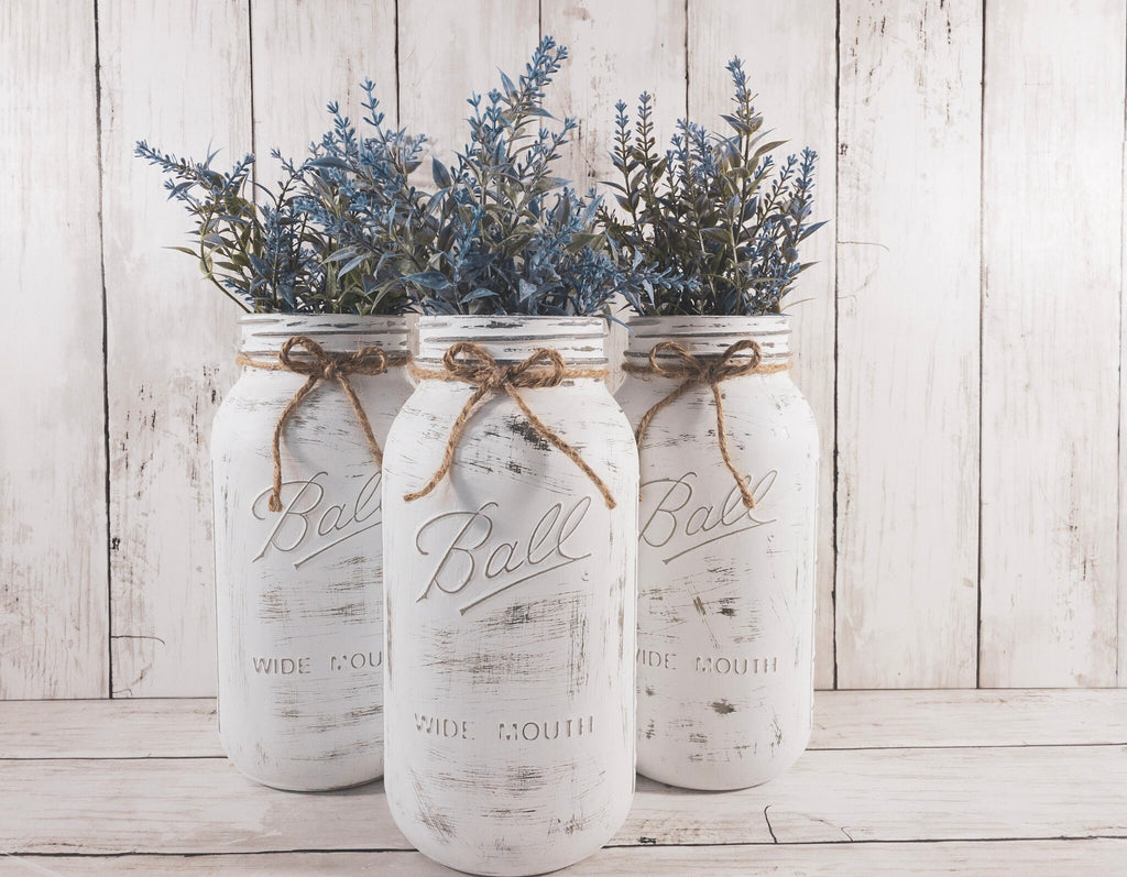 Set of 3 distressed white Ball mason jars with jute twine bows and blue lavender greenery close up