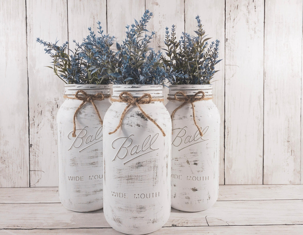 Set of 3 distressed white Ball mason jars with jute twine bows and blue lavender greenery close up