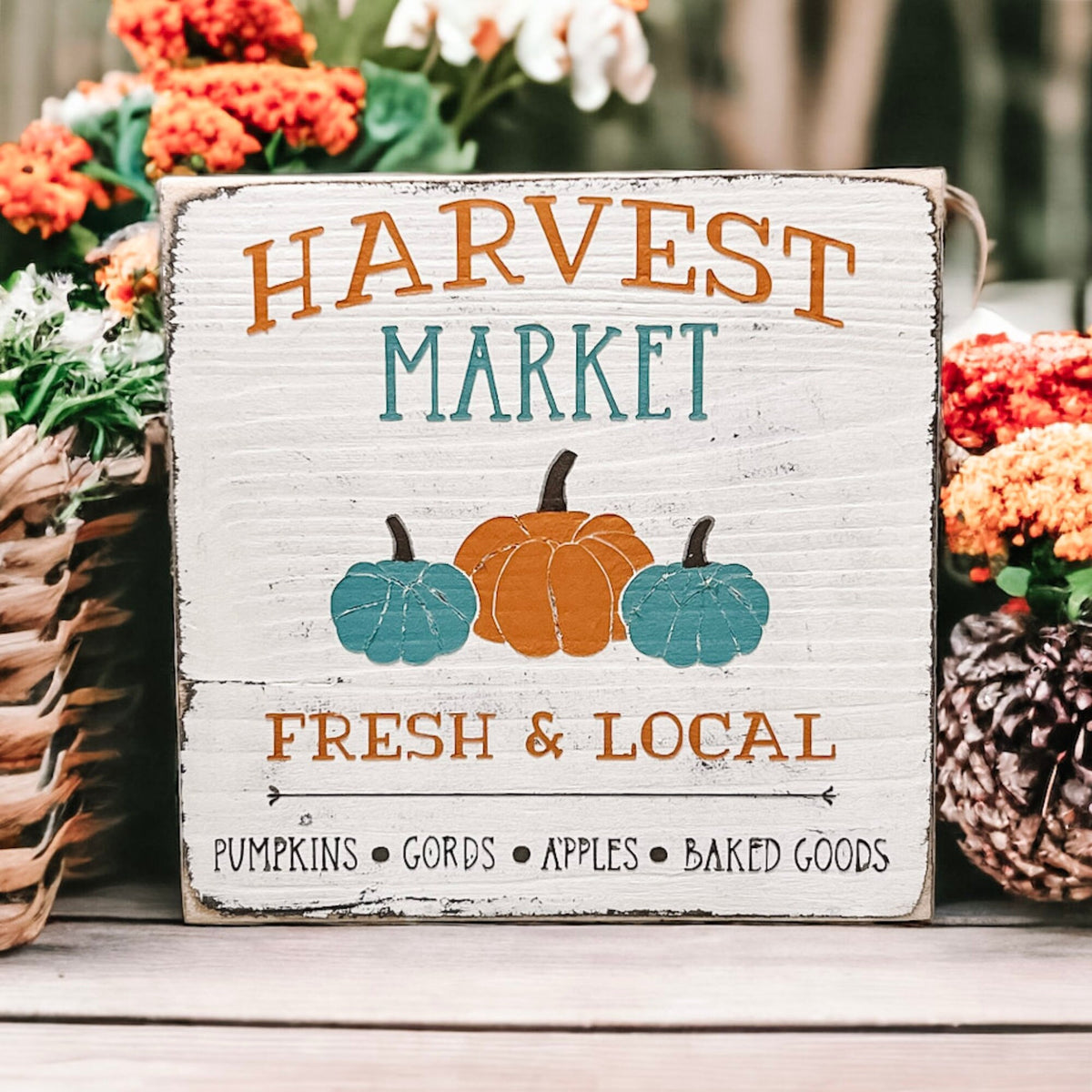 Harvest Market sign on wood surface with orange flowers overhead