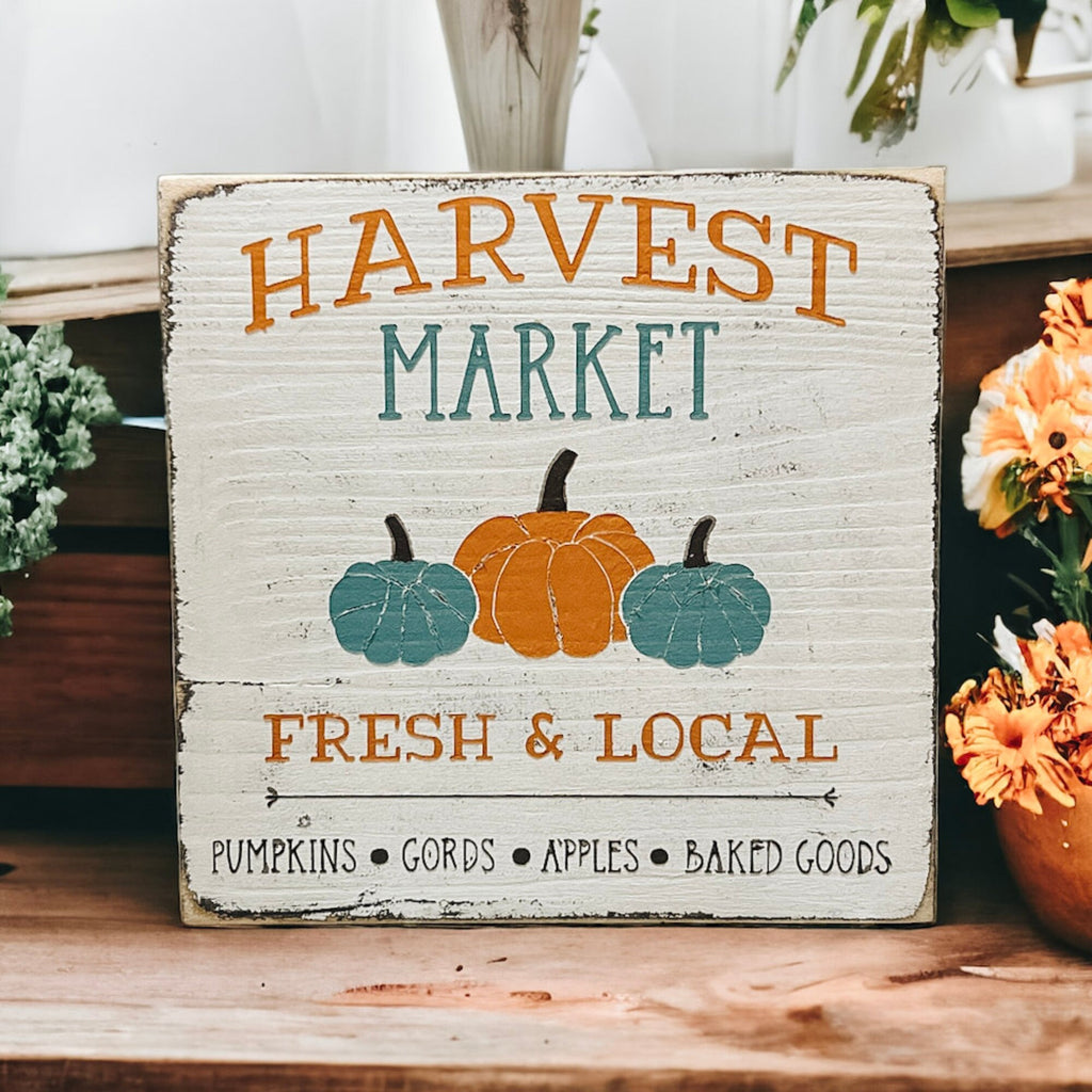 Harvest Market sign styled with orange mums and white pumpkin