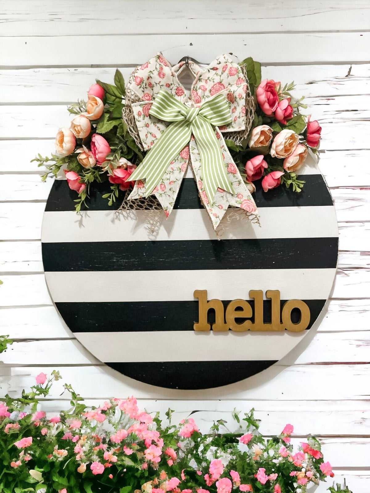 Hello black and white striped round door hanger with pink floral bow product shot on white shiplap wall