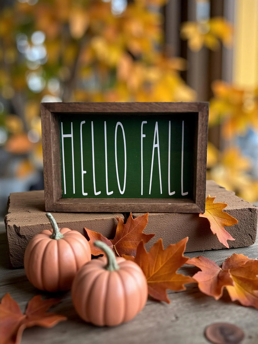 Hello Fall pine green framed wood sign on stone steps with pink pumpkins and fall leaves