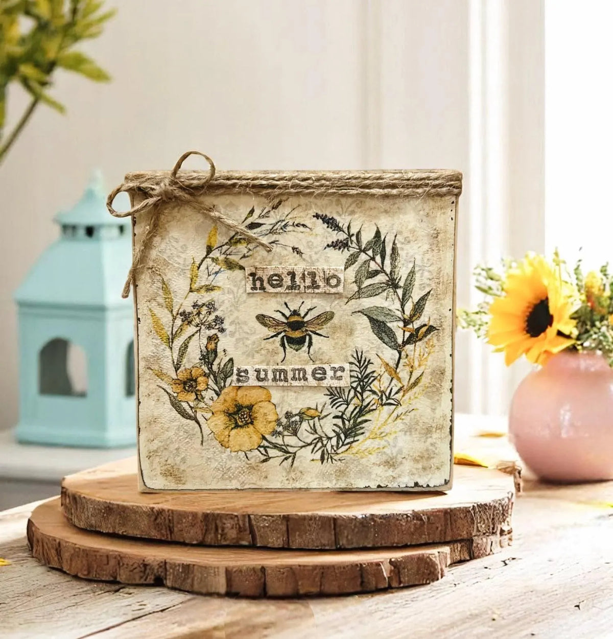 Hello Summer bee sign on wood slice with teal lantern and sunflower arrangement