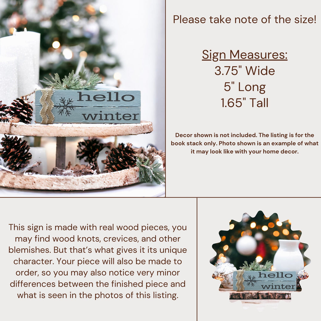Hello Winter dusty blue wood book stack with snowflake and burlap ribbon on dark tiered tray with white candles and Christmas tree