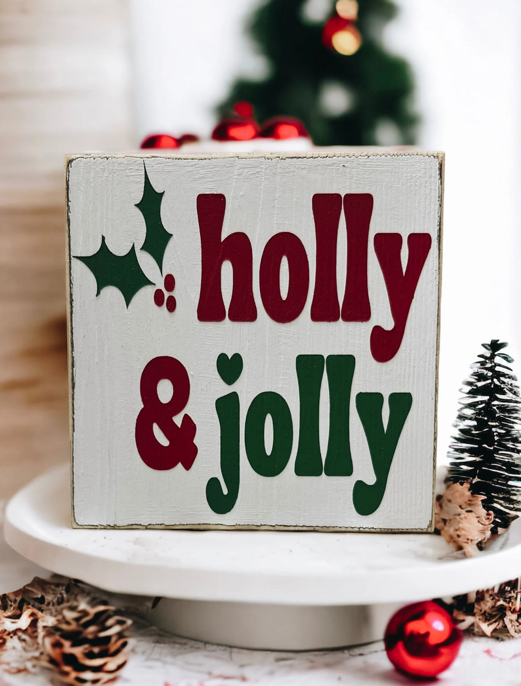 Holly & Jolly wood sign on wood tray with mini Christmas trees overhead angle