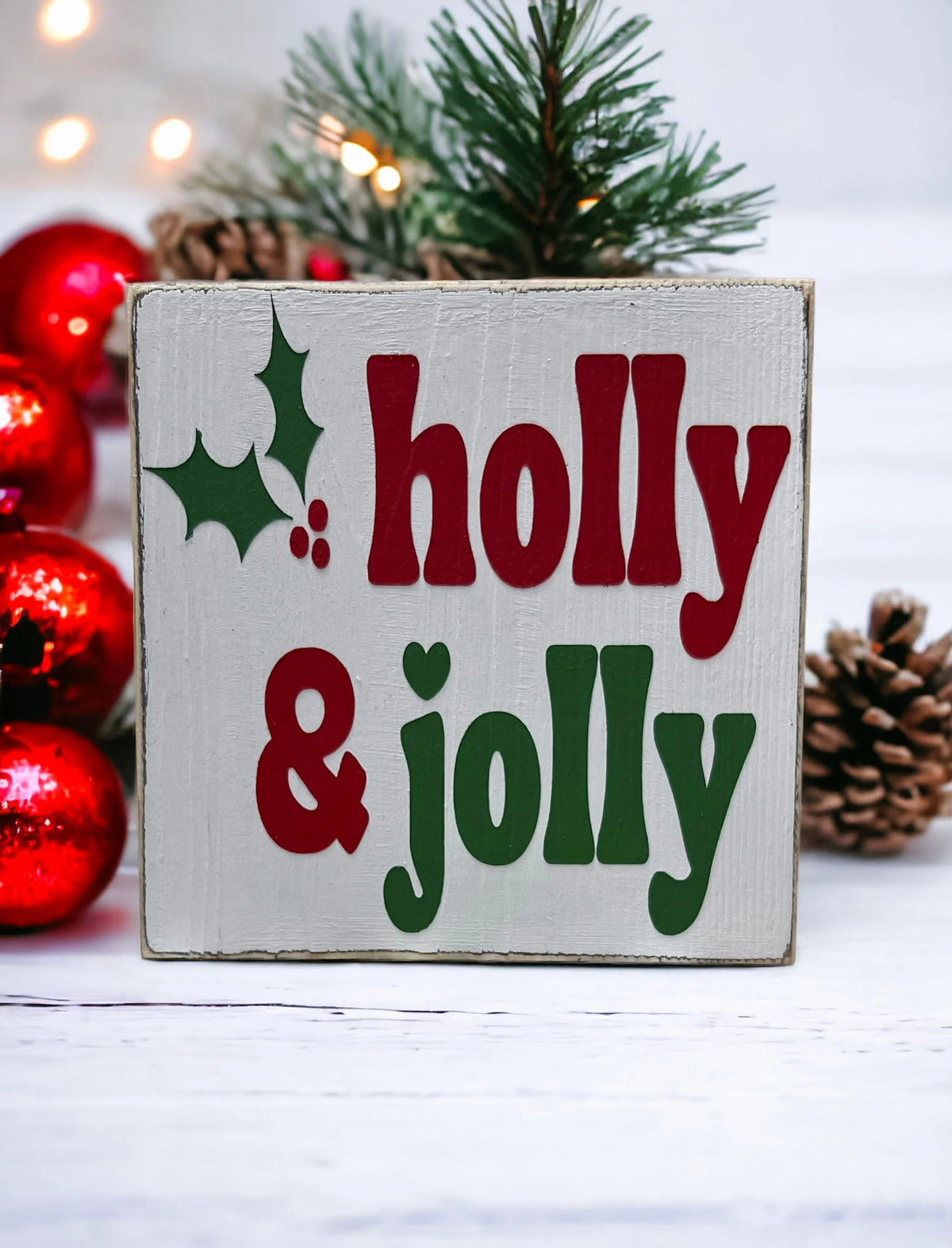 Holly & Jolly wood sign with pine garland and silver and red ornaments